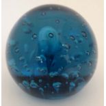 A dark turquoise / blue paperweight of spherical form with air inclusions.