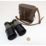 A cased pair of early 20thC binoculars, of brass construction with sun shades,