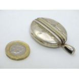 A white metal locket of oval form approx 2" long CONDITION: Please Note - we do