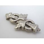 A white metal brooch with engraved acanthus decoration 2 3/4" wide CONDITION: