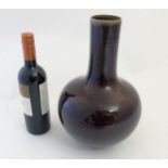 A Chinese Sang de Boeuf bottle vase with globular body and tall cylindrical neck,
