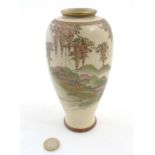 A Japanese Satsuma vase depicting a pagoda garden scene with wisteria decoration along to the top,
