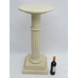 A faux marble made wooden pedestal comprising of an oval top supported on a fluted column and