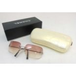 A pair of Chanel pink tinted sunglasses with diamante Chanel logo,