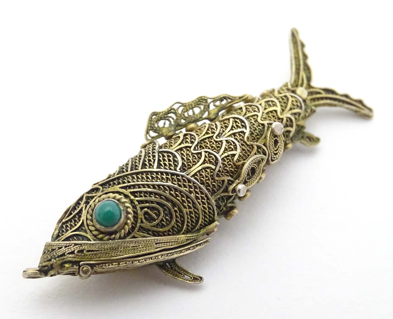 A silver gilt pendant formed as an articulated fish with green stone eyes hinging open to reveal - Image 4 of 6