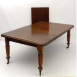 A late 19thC mahogany extending dining table with thumb moulded edge and reeded tapering legs