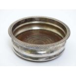 A silver plate coaster with gadrooned rim and turned wooden base 4 1/2" diameter