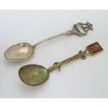 A silver teaspoon the handle surmounted by image of figures in a boat with green enamel and fish