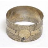 A silver napkin ring with engine turned decoration hallmarked Chester 1921 maker E J Trevitt & Sons.