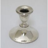 A silver candlestick hallmarked Birmingham 1911 maker Henry Clifford Davis.