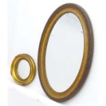 A Victorian gilt circular convex mirror together with an early 20thC gilt oval mirror.