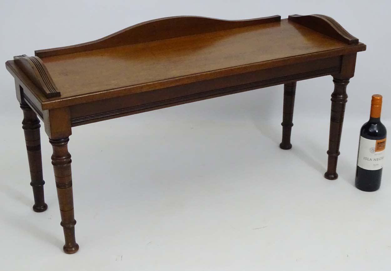 A late 19thC mahogany duet stool / hall seat with shaped upstand,