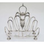 A silver plate toast / letter rack with scroll and shell decoration 7" high x 6 3/4" long