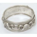 A white metal bangle bracelet with banded decoration CONDITION: Please Note - we