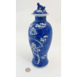 A blue and white Oriental lidded vase of baluster form, decorated with white Prunus flowers to body,