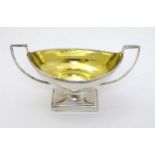 A large Irish silver salt of boat form with gilded interior and having twin handles and on a