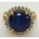 A 14k gold ring set with central blue cabochon bordered by diamonds CONDITION: