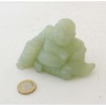 An oriental jade (pale green) carved figure of a seated buddha 4 3/4" wide x 2 7/8" high