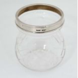 A cut glass pot with silver rim hallmarked London 1933 maker Henry Hobson & Sons.