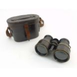A pair of c.1900 leather cased and leather covered binoculars with sun shades.