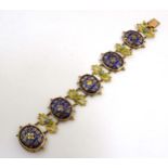 A 19thC gilt metal bracelet set with oval cabochon with blue enamel detail flanked by turquoise.