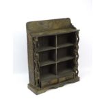 A 20thC tribal bookcase with inset carved upstand,