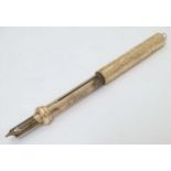 A yellow metal pencil with engraved decoration 2 1/4" long (closed) CONDITION: