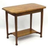 Arts and Crafts: An early 20thC oak two tier side table with Mackmurdo style feet.