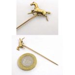 A gold and yellow metal stick in surmounted by a horse. Marked 10k.