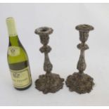 A pair of silver plate candlesticks with profuse fruiting vine decoration.