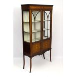 An Edwardian mahogany display cabinet with two astragal glazed doors,