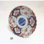 An Oriental Imari style plate with scalloped edges with stylized floral design to centre and other