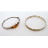 Two silver bracelets one having amber decoration. Prov: Formerly from the Toni Parks UK Collection.