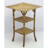 A Late 19thC 3-tier bamboo occasional table with rattan top, standing on four splayed legs.
