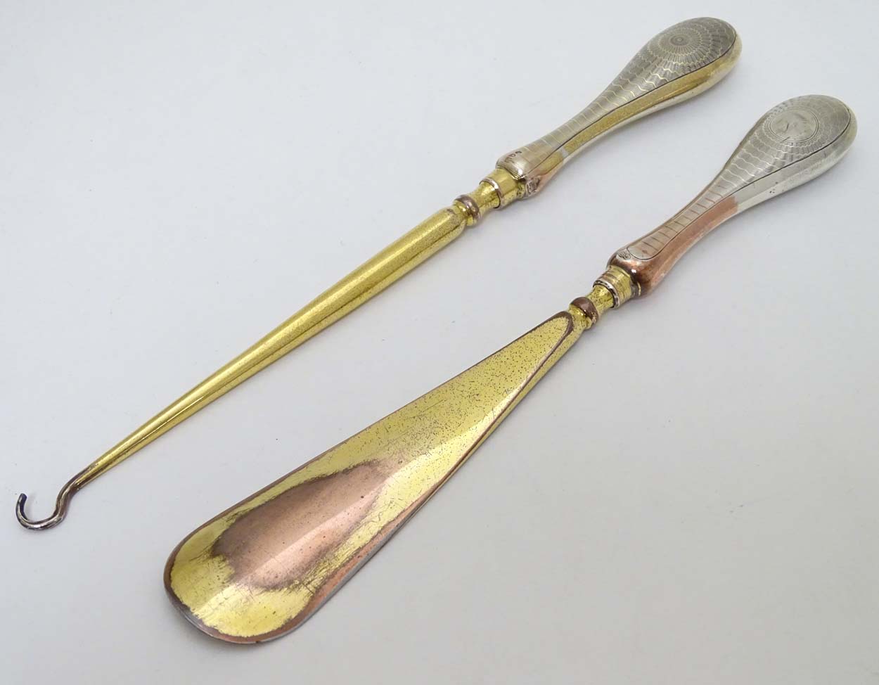 Silver handled button hook and shoe horn with engine turned decoration and traces of gilding.