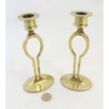Arts & Crafts : A pair of late 19thC brass candlesticks of shaped form 7" high
