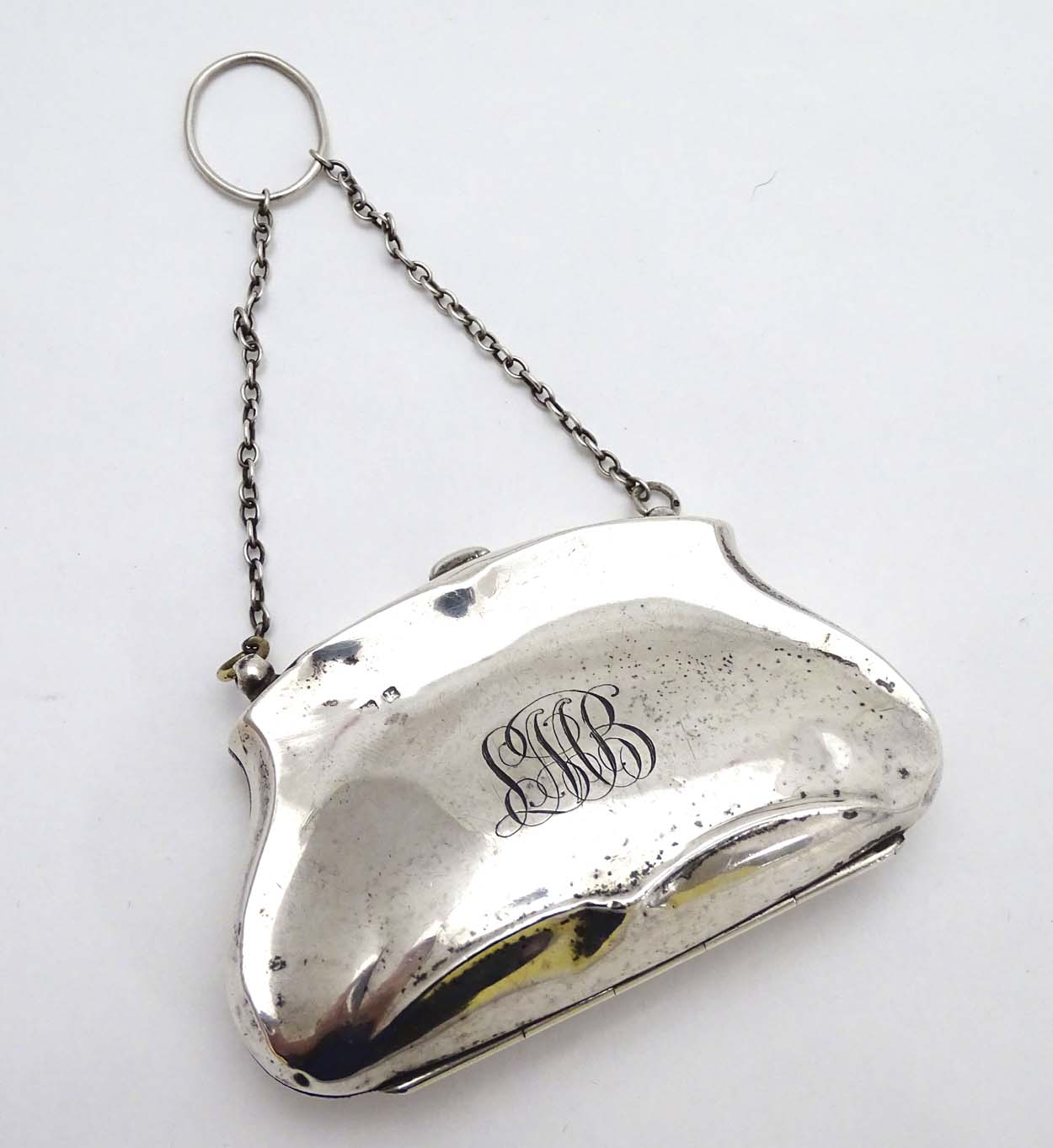 A silver purse with brown leather interior. Hallmarked Birmingham 1909.