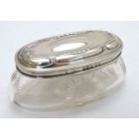 A glass dressing table pot with cut roundel decoration and silver lid hallmarked Birmingham 1910