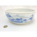 A Chinese blue and white bowl decorated in an underglaze blue continuous landscape and iron red