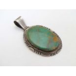 A silver pendant set with green stone cabochon marked LTP Sterling.