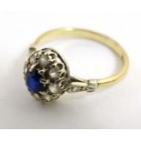 A 9ct gold ring set with central blue stone bordered by white stones CONDITION: