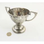 WMF A twin handled silver plate pedestal trophy cup with embossed decoration.