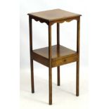 An early 19thC mahogany two tier night stand / bedside table with shaped apron and single drawer,