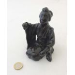 A 19thC Japese Meiji patinated bronze in the form of a female kneeling.
