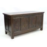 An 18thC oak four panelled coffer with carved diamond decoration and a nulled frieze,