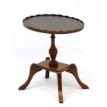 A 21stC mahogany wine table of small proportions with inset leather top and pie crust edge,