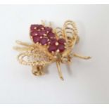 A 14k gold brooch formed as a bee / winged insect set with rubies to body and diamonds to eyes.