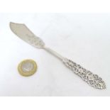 A silver handled butter knife with openwork decoration to handle.