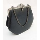 A small ladies black evening purse with silver coloured hardware and chain handle,
