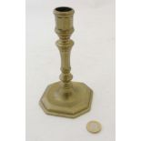 An 18thC spun brass candlestick with octagonal foot.